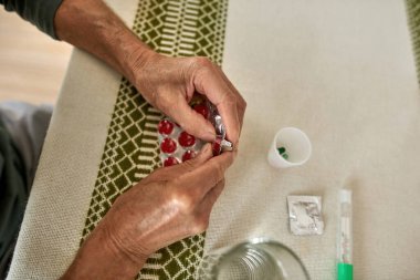 Yaşlı hastaların bir kısmı paketten hap alıyor.