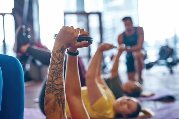 Женщины делают упражнения с дисками веса в тренажерном зале — стоковое фото