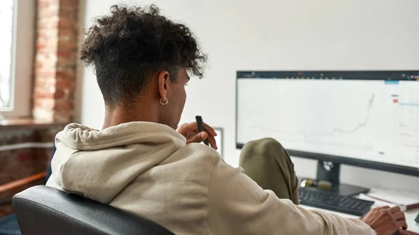 Inversionista comerciante afroamericano vapeo dispositivo electrónico mientras trabaja en PC — Foto de Stock