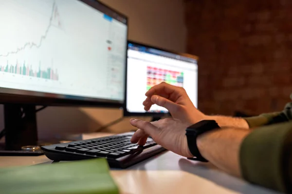 Trader typing on computer with blurred chart — Stock Photo, Image