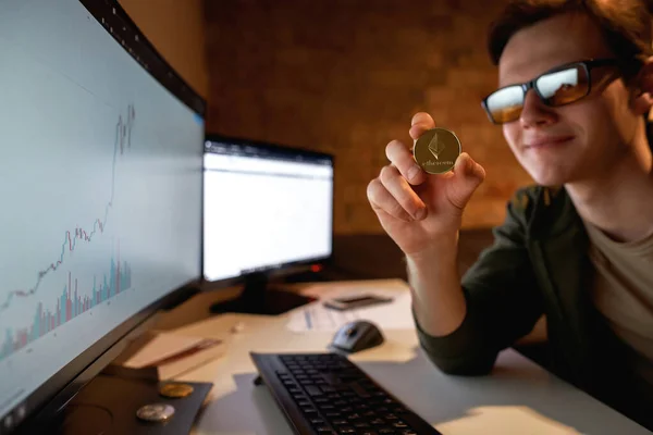 Hombre comerciante mostrando cripto moneda cerca de la computadora —  Fotos de Stock