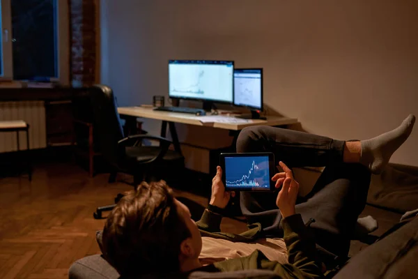 Hombre viendo gráfico en tableta digital en sofá — Foto de Stock