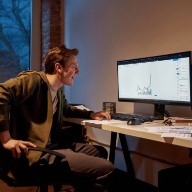 Neşeli erkek tüccar iş grafiğini izliyor.