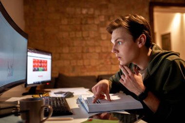 Erkek tüccar kitap okur ve finansal grafiği izler