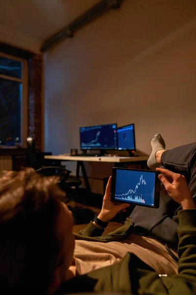 ソファの上のデジタルタブレット上の投資家の監視チャート — ストック写真