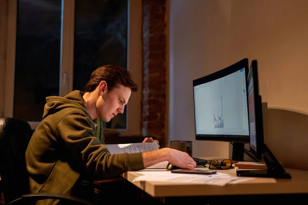 Männlicher Händler liest während der Arbeit Lehrbuch — Stockfoto