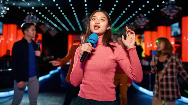 Asian teen with friends dancing and singing at karaoke club — Stock Photo, Image