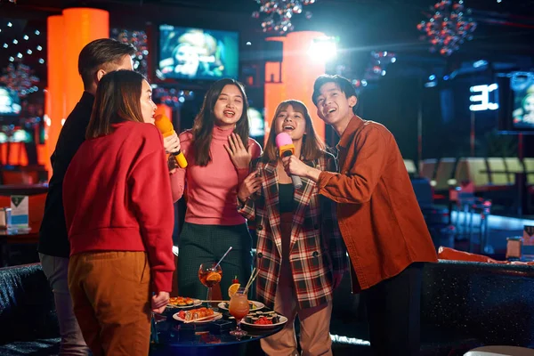 Grupo de jóvenes asiáticos disfrutando en la discoteca karaoke — Foto de Stock