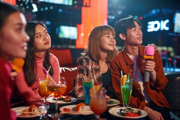 Grupo de chicos y chicas asiáticos cantando canciones en el club de karaoke — Foto de Stock