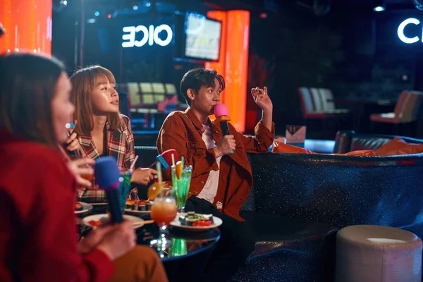 Grupp asiatiska vänner som har roligt och sjunger låtar på karaokeklubben — Stockfoto