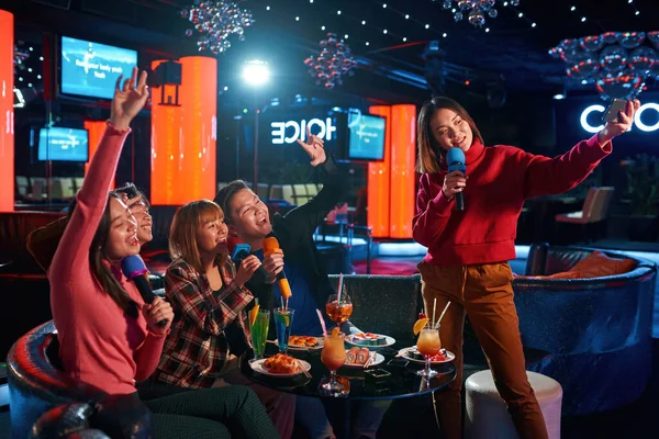 Grupo asiático de amigos cantando canciones en el club de karaoke — Foto de Stock