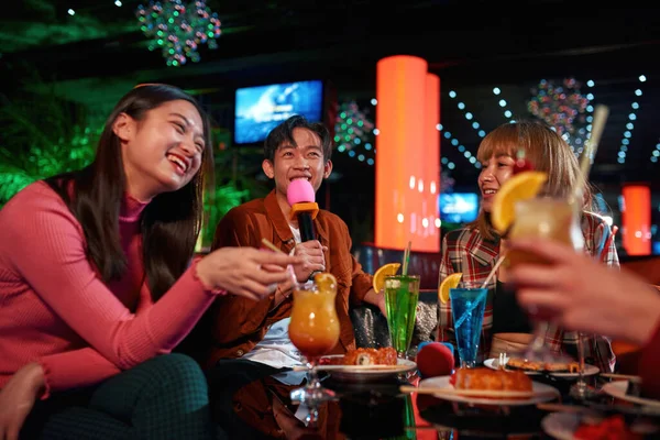 Amigos asiáticos brindando con cócteles y riendo juntos — Foto de Stock