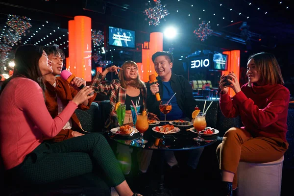 Grupo de amigos divirtiéndose y celebrando en el club de karaoke — Foto de Stock