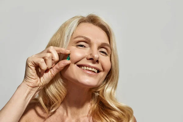 Cropped of mature woman showing beauty capsule — Stock Photo, Image