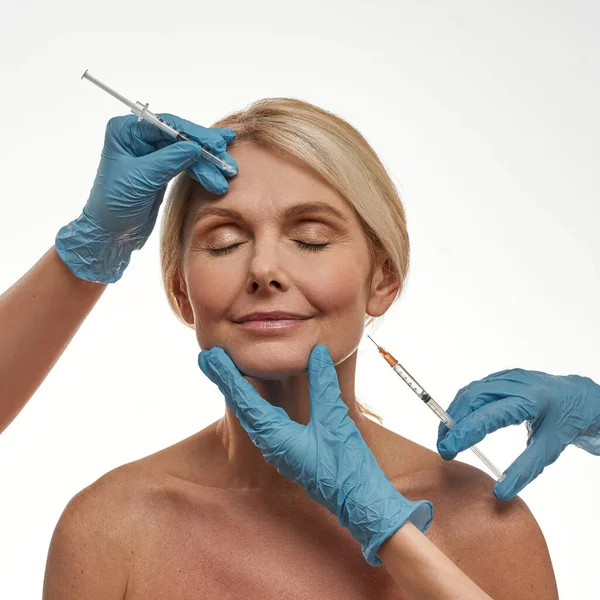 Lekarz wykonujący wstrzyknięcie botexu na twarz kobiety — Zdjęcie stockowe