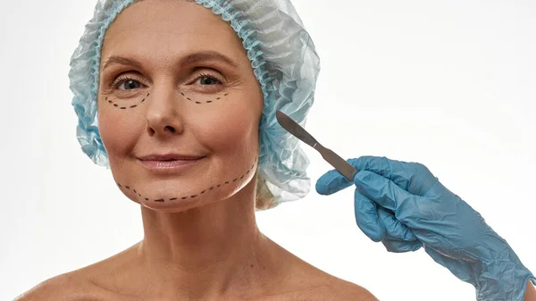 Cirurgião plástico mãos com bisturi perto da mulher rosto — Fotografia de Stock