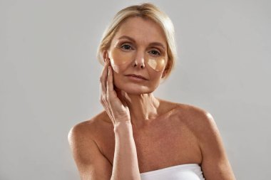 Yüzünde göz bandı olan beyaz bir kadın.