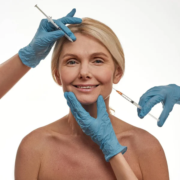 As mãos de doutor fazem a injeção de botex no rosto de mulher — Fotografia de Stock