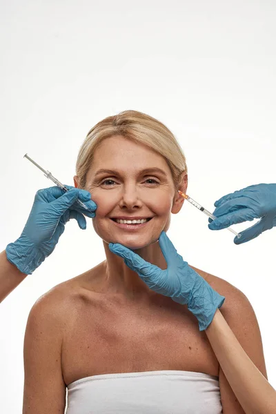 Médicos fazem injeção com seringa na face feminina — Fotografia de Stock