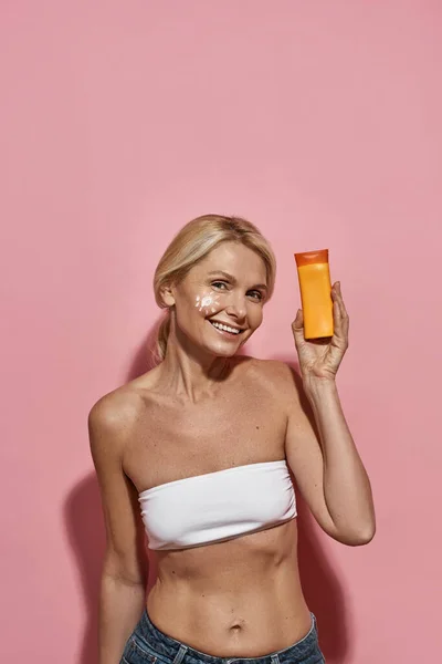Smiling mature caucasian woman with sun cream — Stock Photo, Image