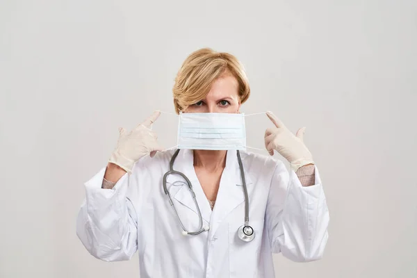 Γυναίκα γιατρός που βάζει ιατρική μάσκα στο πρόσωπό της — Φωτογραφία Αρχείου