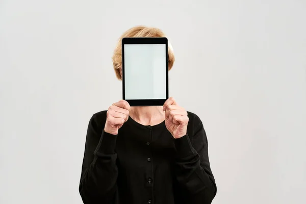 Femme d'âge moyen couvrir visage avec tablette numérique — Photo