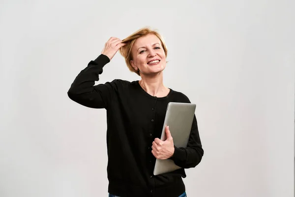 Mujer con el pelo del tacto portátil y mirar a la cámara —  Fotos de Stock