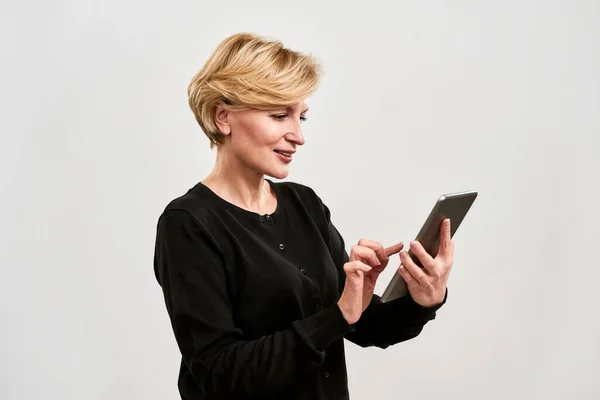 Donna adulta che utilizza e guarda su tablet digitale — Foto Stock
