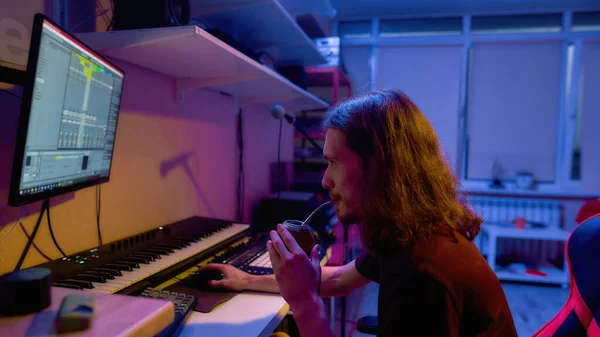 Hombre beber mate durante la fabricación de música en el ordenador — Foto de Stock