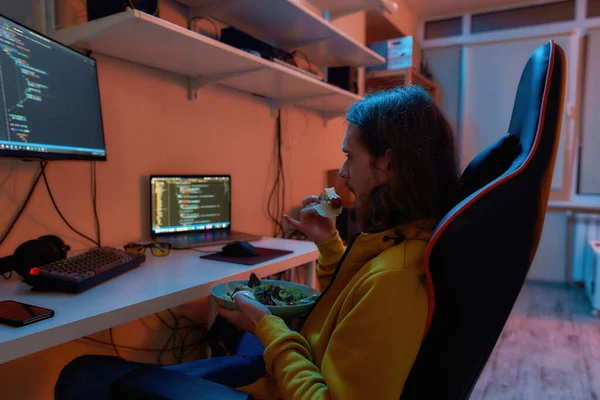 IT geliştiricisinin yan görünümü program sırasında salata yiyor — Stok fotoğraf