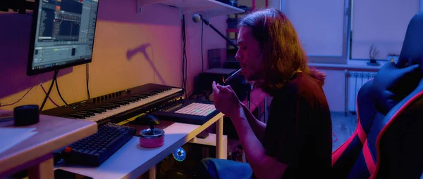Compositeur masculin cigarette légère pendant faire de la musique — Photo