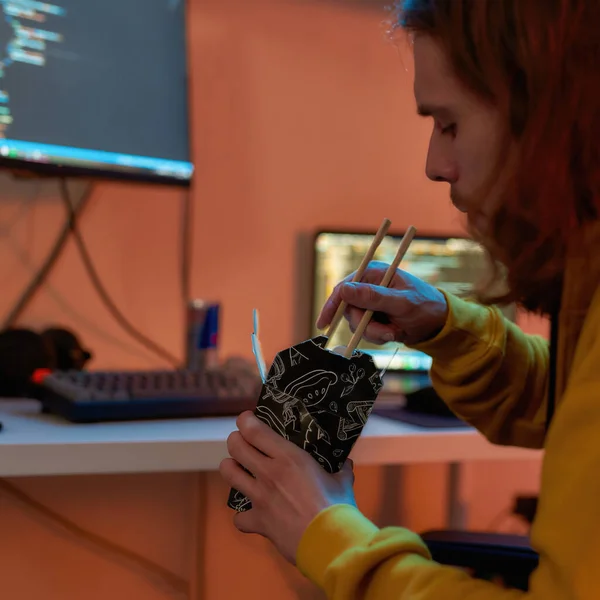 Προγραμματιστής ΤΠ που τρώει τρόφιμα ενώ προγραμματίζει κώδικα — Φωτογραφία Αρχείου