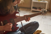 Částečný běloch hrající na elektrickou kytaru
