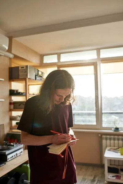 Jeune homme concentré écrivant le texte d'une nouvelle chanson — Photo