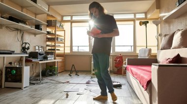 Genç odaklı adam evde yeni şarkılar yazıyor.