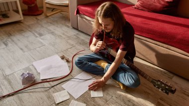 Gitarlı adam yeni şarkının metnini düşünüyor.