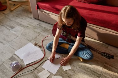 Elektro gitarlı adam yeni şarkının metnini yazıyor