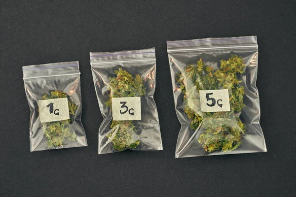 Набір пакетів з марихуаною на чорному тлі — стокове фото