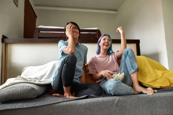 Feliz pareja femenina viendo la televisión, divirtiéndose —  Fotos de Stock