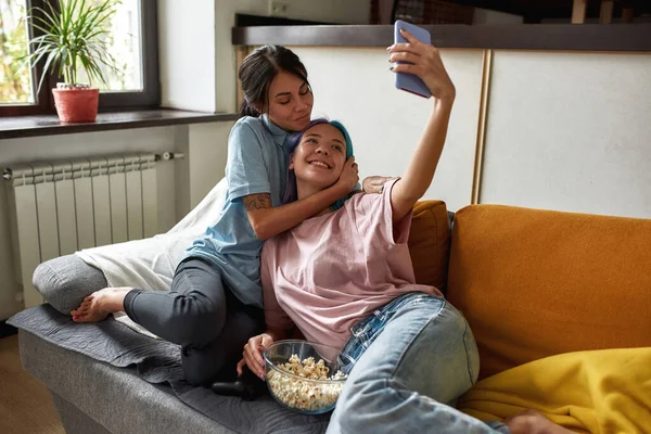 Adorável casal lésbico tomando selfie na sala de estar — Fotografia de Stock