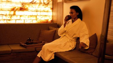 Siyah kız fincandan çay içer ve kaplıcada düşünür.