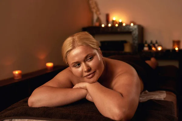 Relaxante mulher descansar na mesa de massagem no salão de spa — Fotografia de Stock