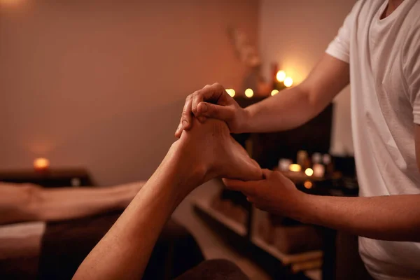 Parcial de massagista fazendo massagem nos pés do homem — Fotografia de Stock