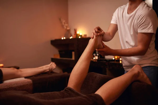 Massagista fazendo massagem nos pés do homem no salão de spa — Fotografia de Stock