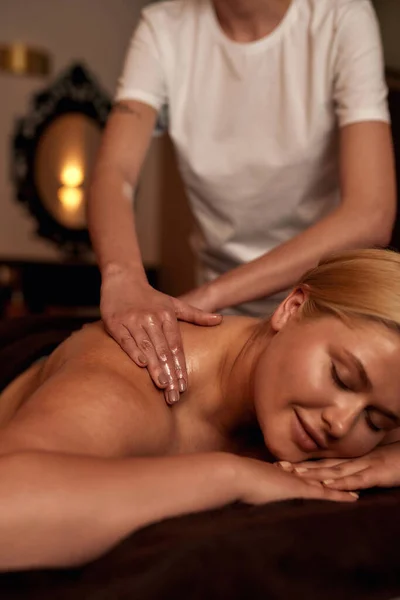 Masseur do back massage of naked girl in spa salon — Stock Photo, Image