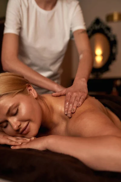 Masér dělá masáž zad relaxační dívky v lázeňském salonu — Stock fotografie