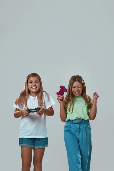 Chicas alegres jugando videojuego con joysticks —  Fotos de Stock