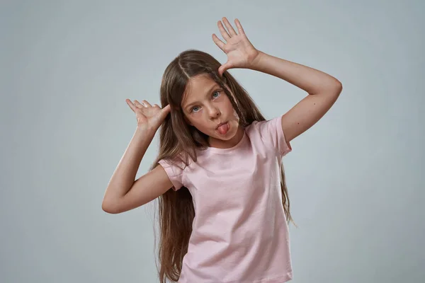 Szórakoztató lány kiáll nyelv és mutasd szarvak gesztus — Stock Fotó