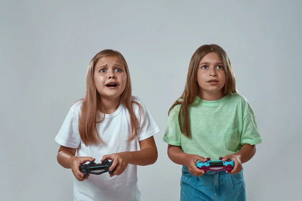 Dos niñas jugando videojuegos con joysticks —  Fotos de Stock