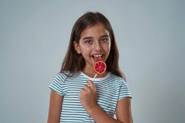 Cropped of pleased little girl lick sweet lollipop — Stock Photo, Image